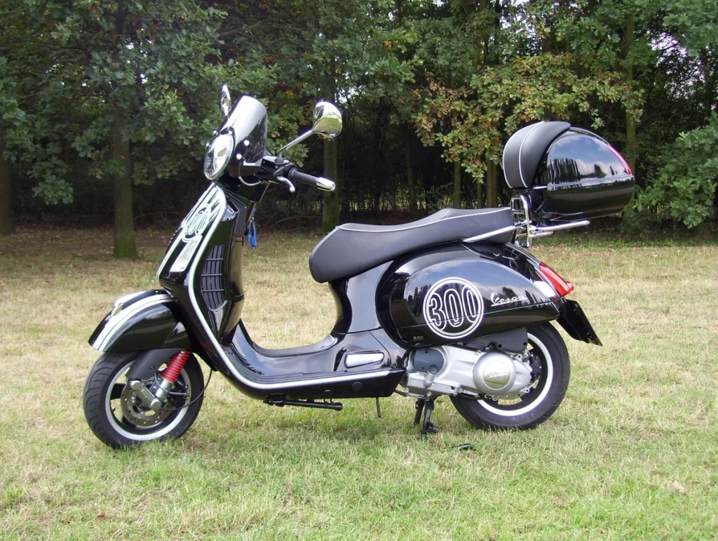 Zwarte Vespa GTS 300 Super motorscooter op gras — populair 300cc-model met hoog diefstalrisico
