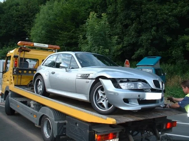 Beschadigde BMW M Coupe na crash op de Nurburgring Nordschleife, geborgen op een dieplader bij Breidscheid