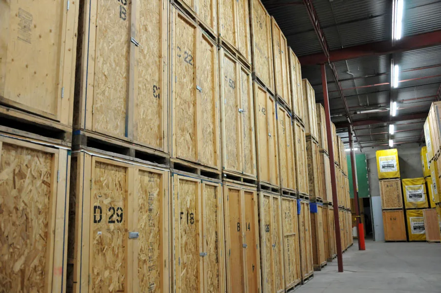 Genummerde houten opslagunits in een self-storage magazijn — verzekering opslagruimte 2026