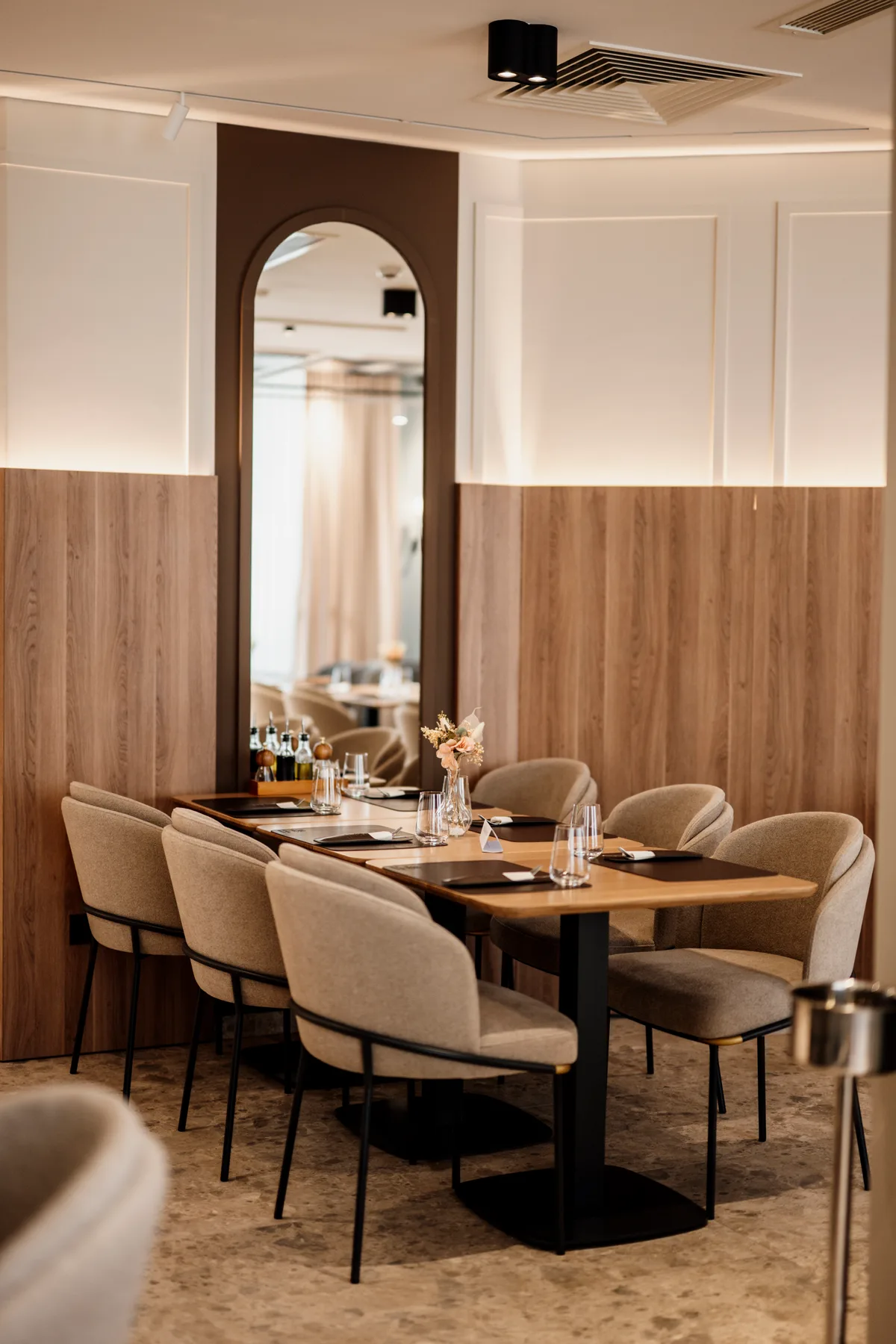 Modern restaurant interieur met gedekte tafels, houten wanden en sfeerverlichting