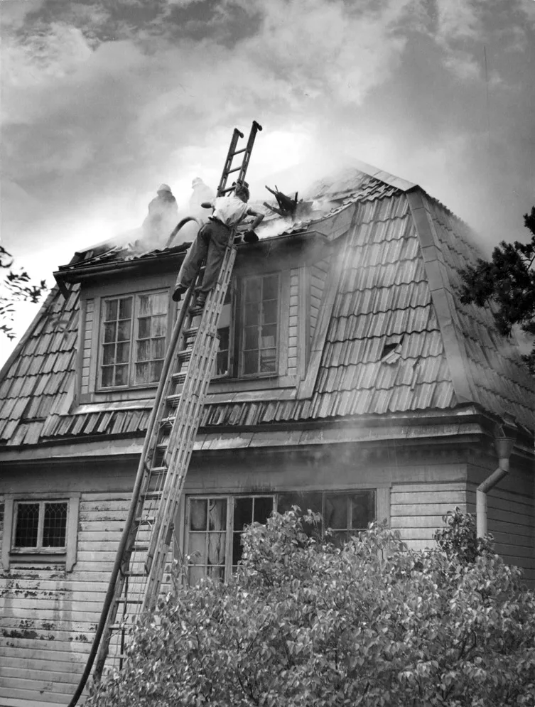 Brandweerlieden blussen een woningbrand bij een huis in Djursholm, illustratie van het belang van een brandverzekering