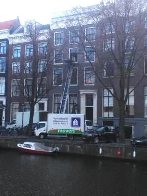 Verhuiswagen van verhuisbedrijf City Movers bij een Amsterdams grachtenpand met verhuislift