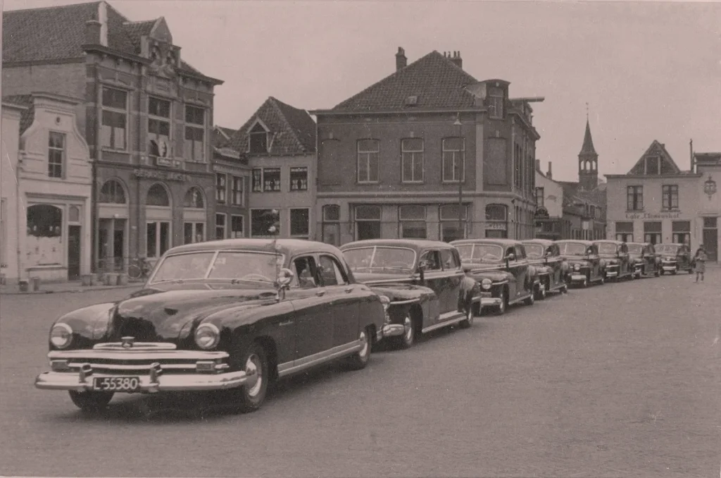 Rij huurwagens van Van Dusschoten Autoverhuur in de binnenstad van Amersfoort, historische vloot autoverhuurbedrijf