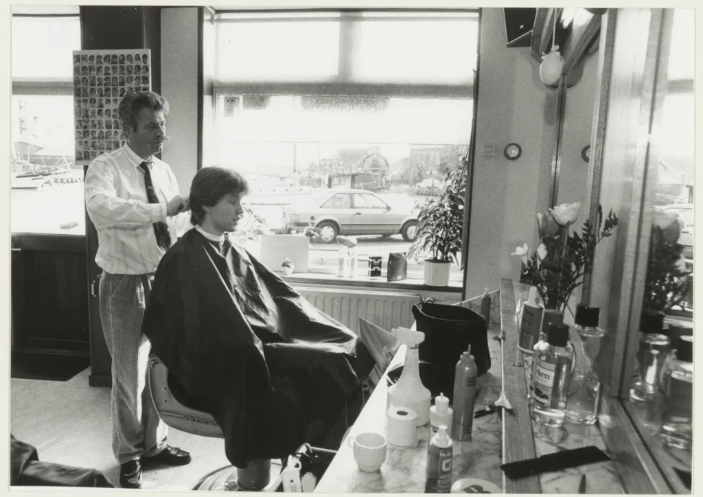 Nederlandse kapper aan het werk in zijn kapsalon, illustratie bij branchespecifieke bedrijfsverzekeringen voor startende ondernemers