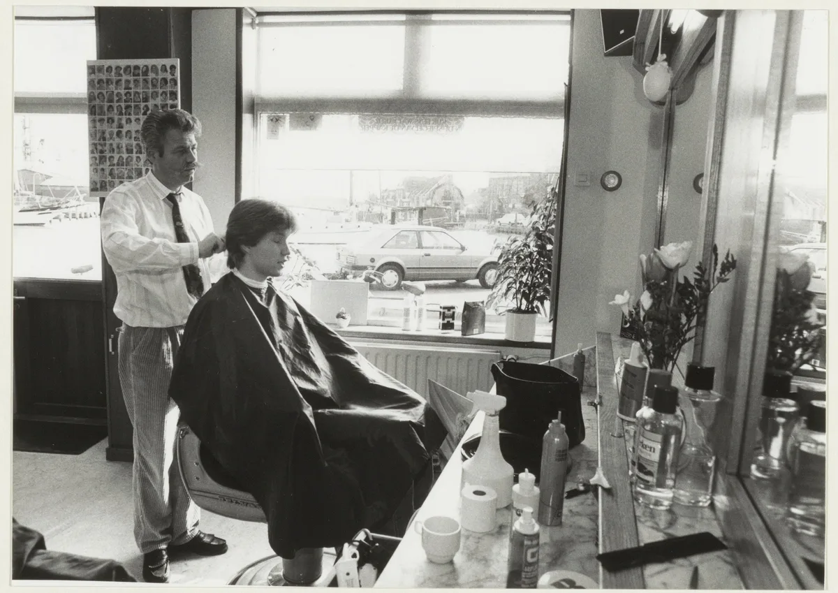 Nederlandse kapper aan het werk in zijn kapsalon, illustratie bij branchespecifieke bedrijfsverzekeringen voor startende ondernemers