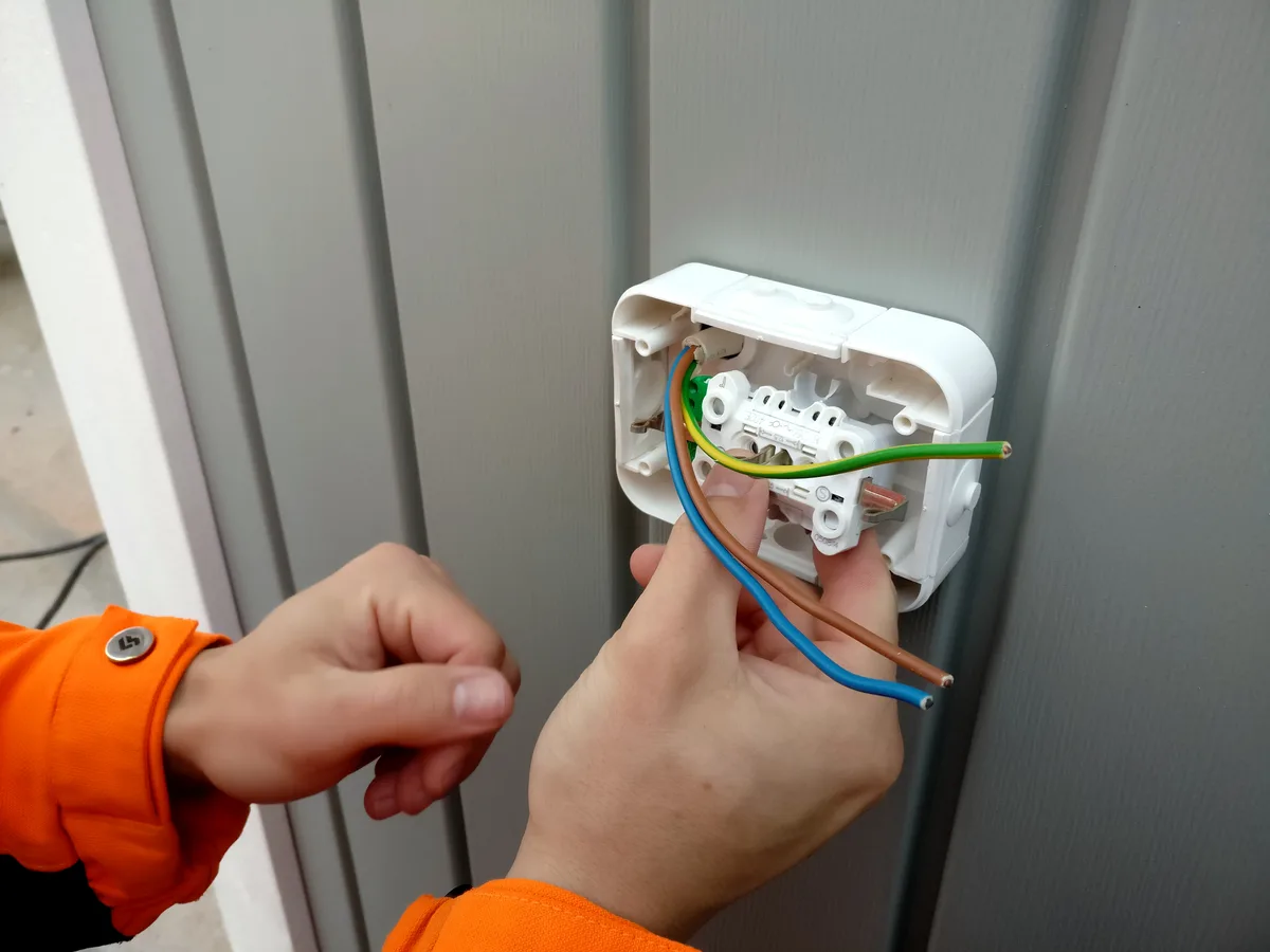 Elektricien ZZP installeert een stopcontact als zelfstandige onderaannemer in de bouw