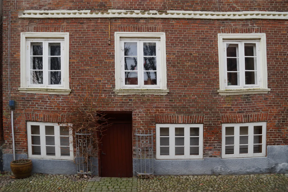 Verzakte woning met scheuren in metselwerk en verzakte vensterlijsten door bodemdaling in Denemarken