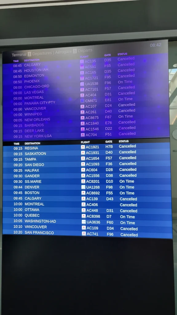 Vertrekbord op luchthaven Toronto met tientallen geannuleerde vluchten - annuleringsverzekering vliegticket