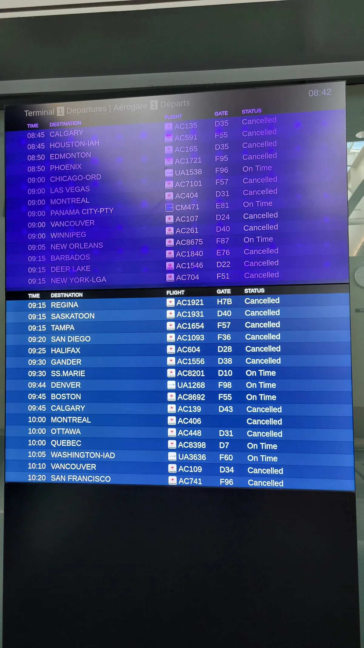 Vertrekbord op luchthaven Toronto met tientallen geannuleerde vluchten - annuleringsverzekering vliegticket