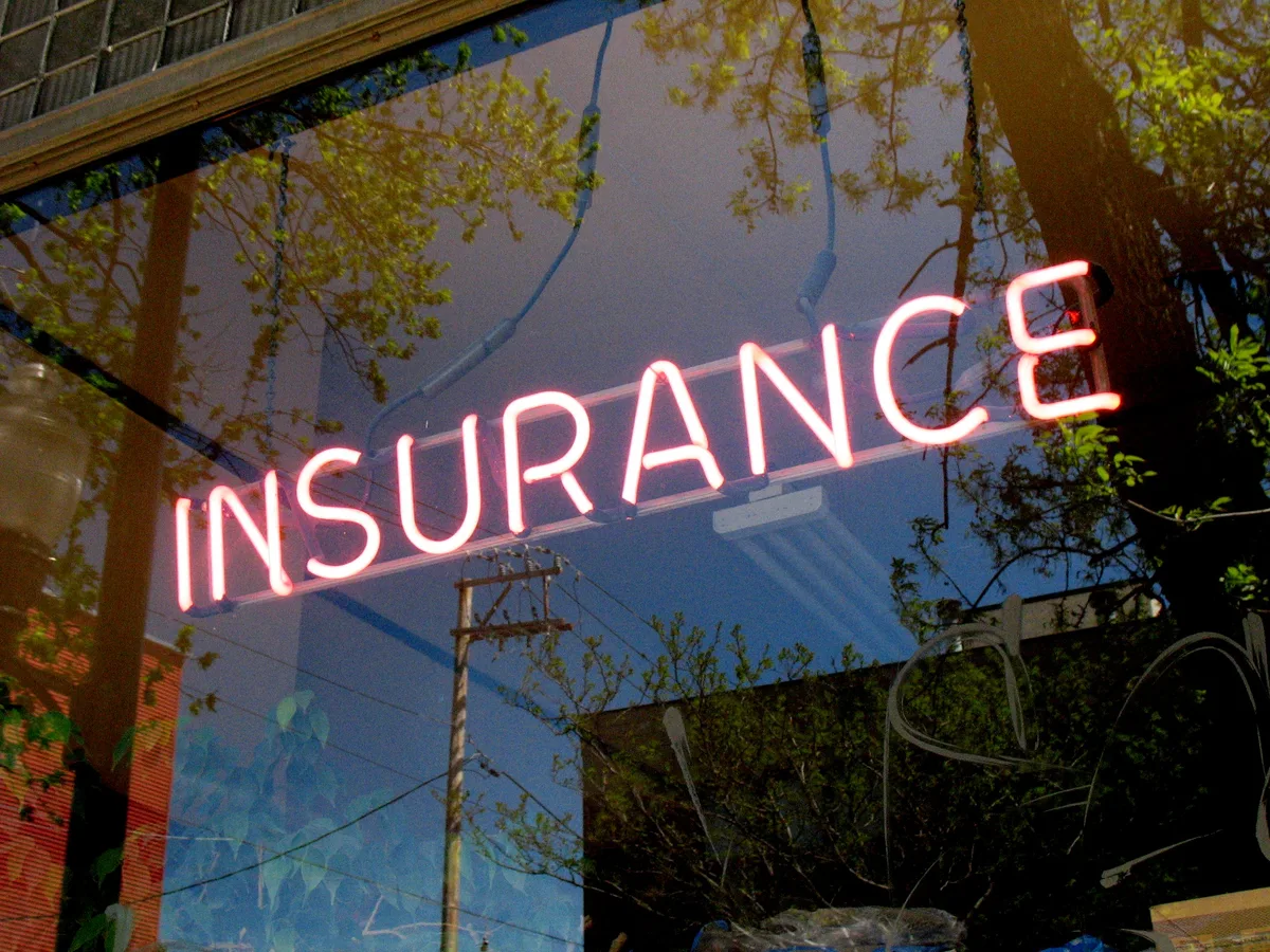 Neonbord met het woord INSURANCE — symbool voor een verzekeringspakket met pakketkorting