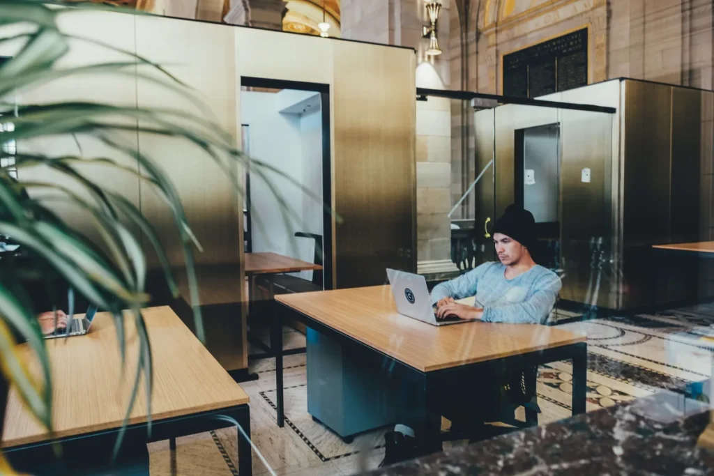 ZZP'er werkt op laptop in modern co-working kantoor — verzekeringen voor zelfstandigen