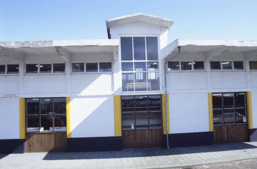 Winkel- en bedrijfspand in Harlingen, Nederland — exterieur met etalageruiten en rolluiken