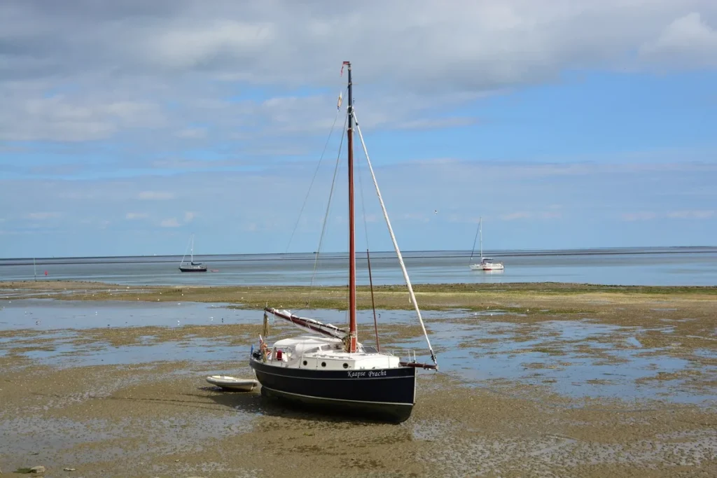 Zeiljacht drooggevallen op het wad bij Vlieland, Nederland - typisch beeld voor zeilen op de Waddenzee
