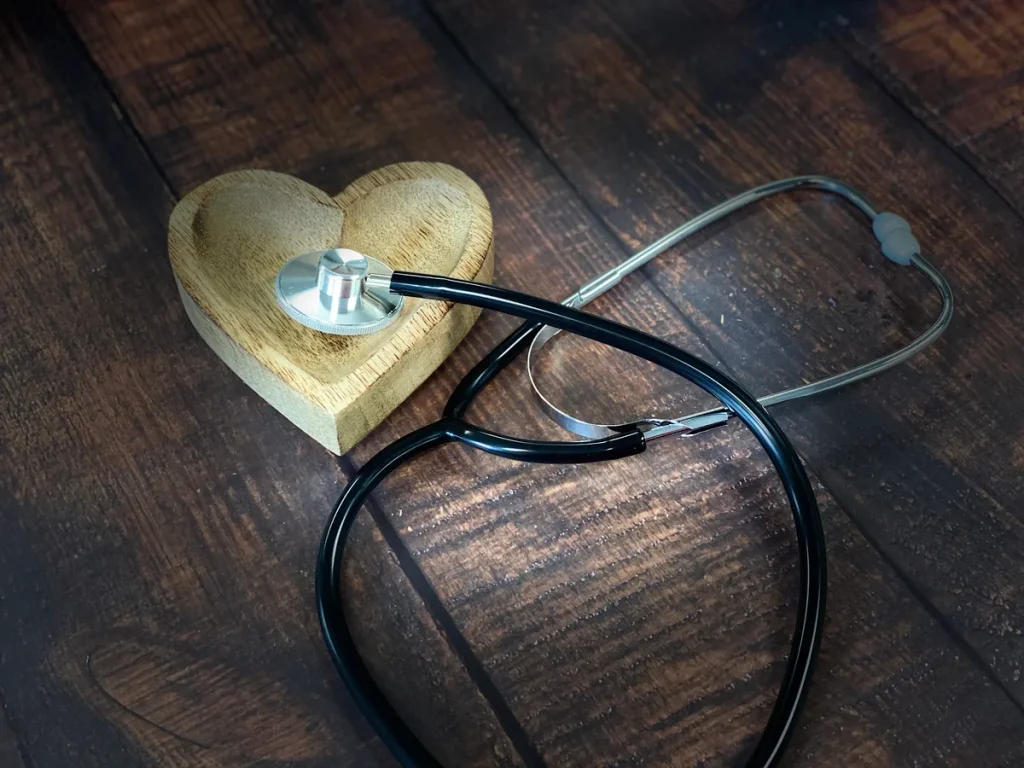 Stethoscoop met houten hart op donker hout — symbool voor zorgverzekering en gezondheid in 2026