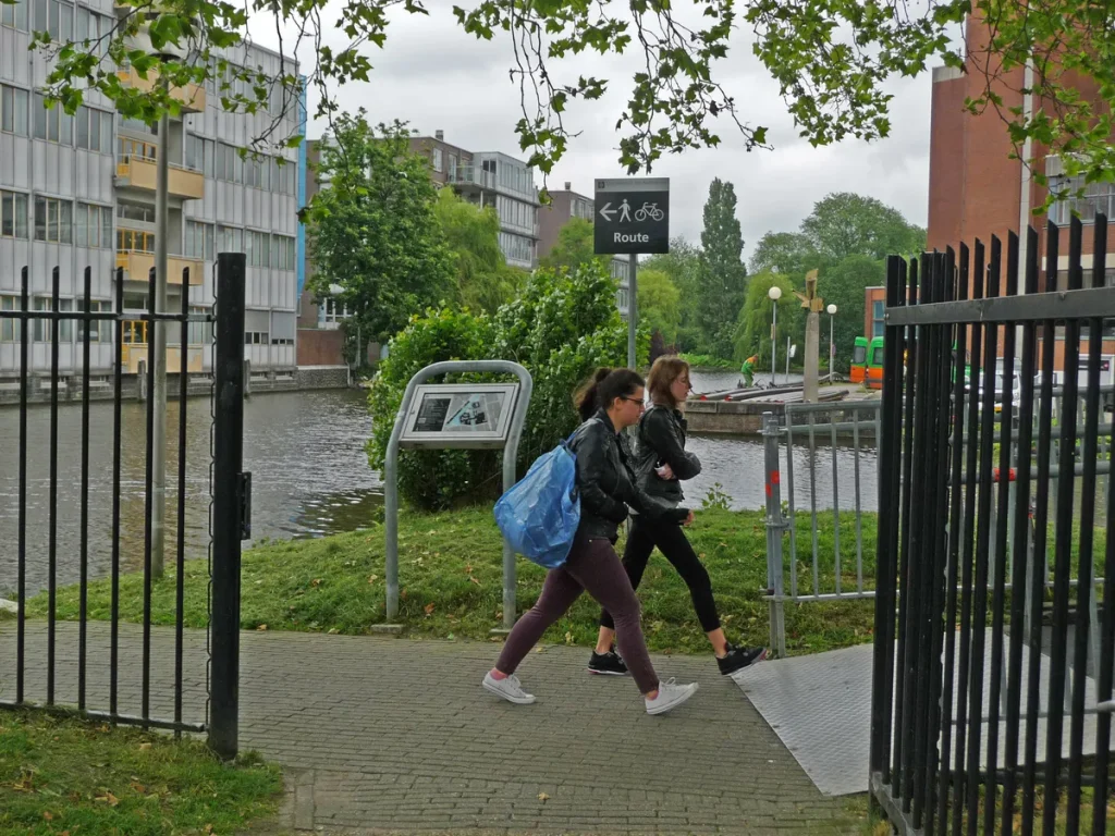 Twee studenten lopen over de universiteits campus Roeterseiland in Amsterdam met een rugzak