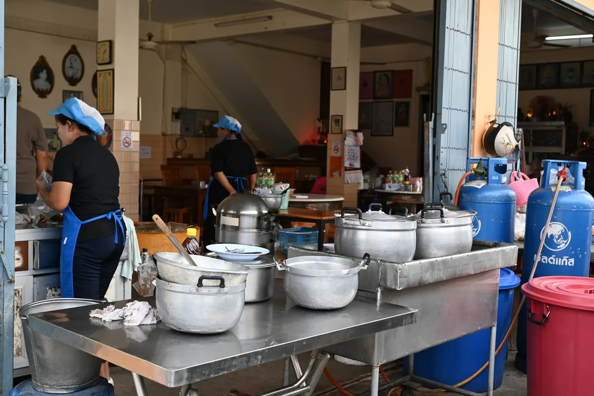 Professionele horecakeuken met keukenpersoneel, grote potten en roestvrijstalen werktafels
