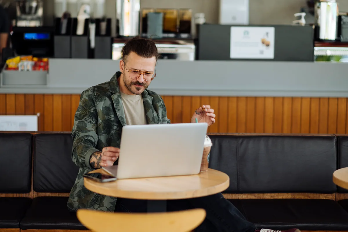 ZZP-er werkt op laptop in cafe - AOV afsluiten als zelfstandig ondernemer 2026